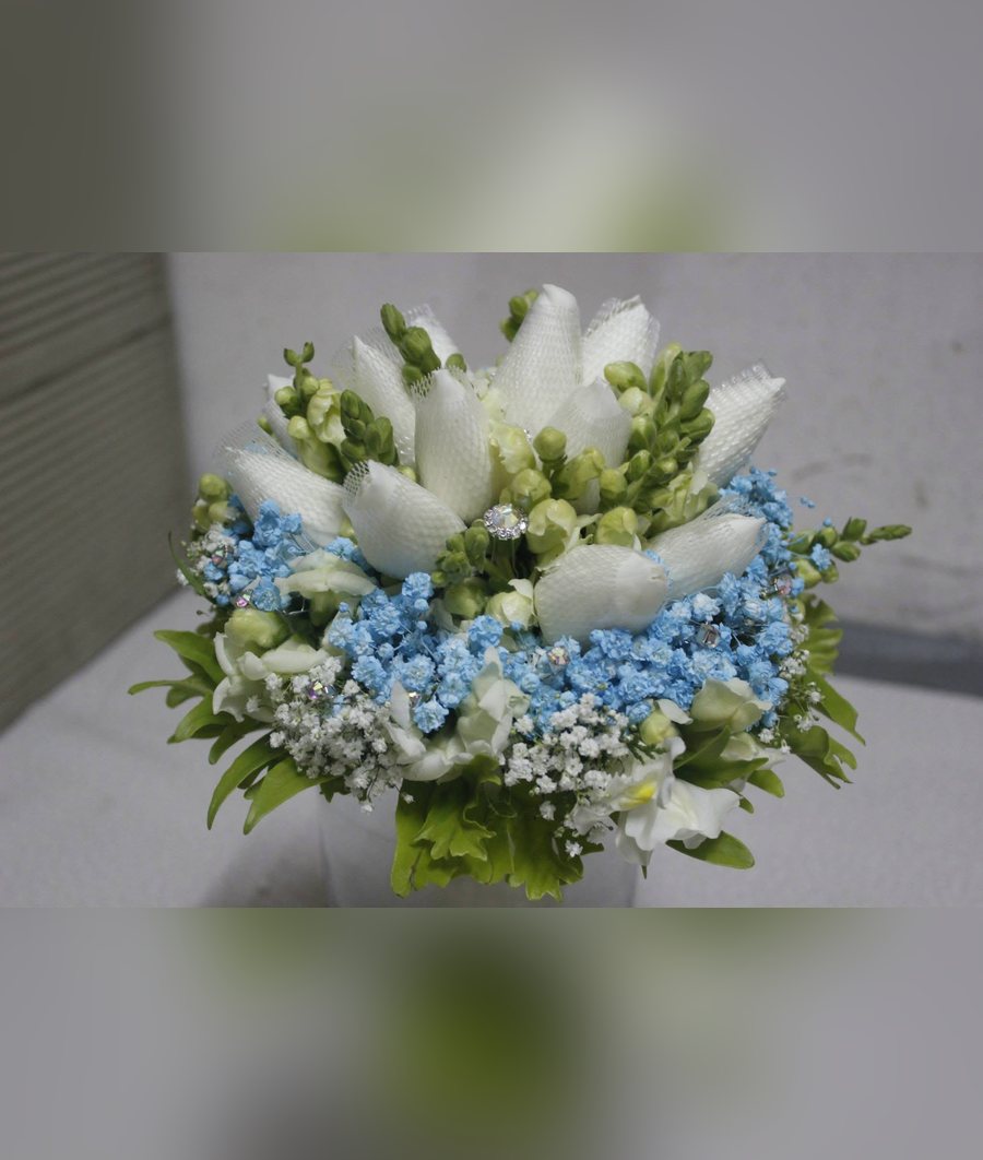 White tulip bridal bouquet with blue baby's breath, snapdragons and crystal accents