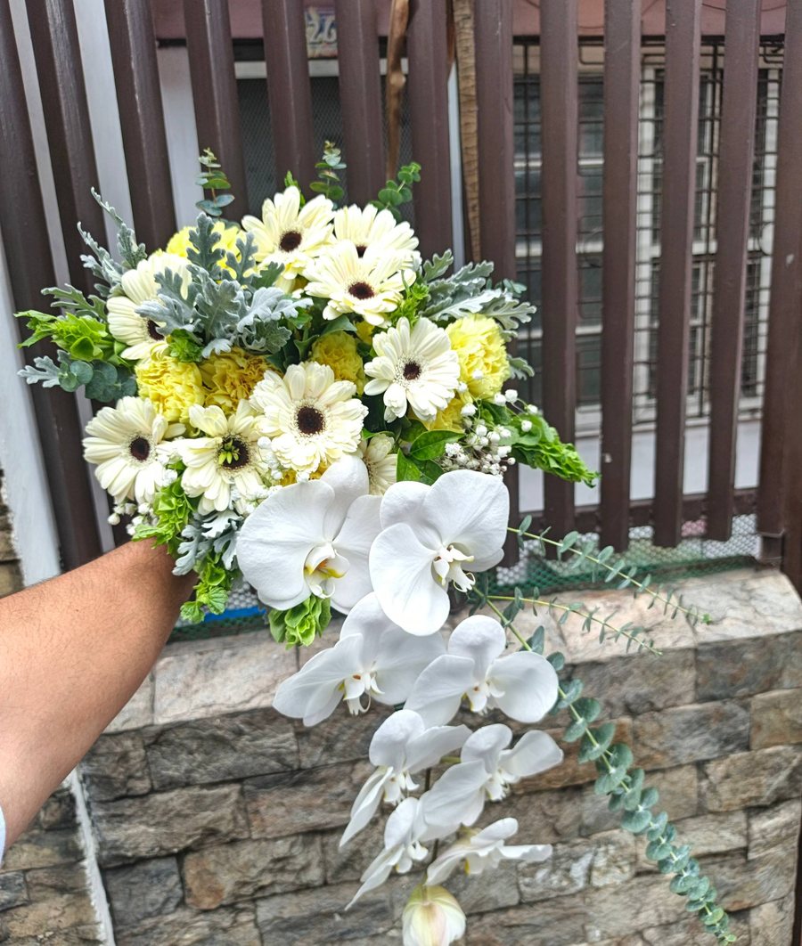 Cascade bridal bouquet with white orchids, cream gerbera, carnations and eucalyptus