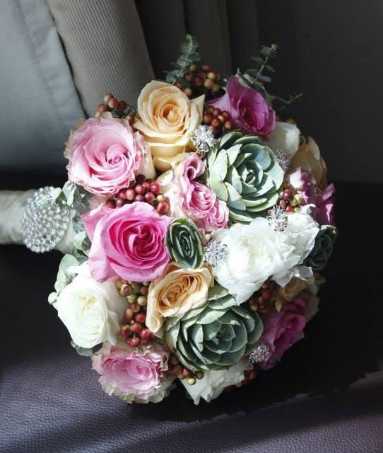 Pink and peach rose bridal bouquet with succulents, berries and jeweled handle wrap